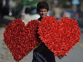 A Pakistani vendor carries heart-shaped bouquets for sale ahead of Valentine's Day along a street in Islamabad on Feb. 13, 2017.