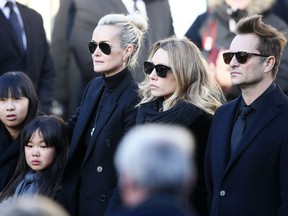 FILE - In this Dec.9, 2017 file photo, French rock star Johnny Hallyday's wife Laeticia, second left, his daughters Jade, left, and Joy, Laura Smet, second right, and son David Hallyday, right, arrive at La Madeleine church for Johnnny Hallyday's funeral ceremony in Paris. The lawyers of Laura Smet, the daughter of late French singer Johnny Hallyday say she will launch a legal challenge to contest her father's will which leaves all his property and artistic rights "exclusively" to his widow Laeticia.