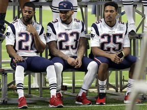 New England Patriots cornerback Malcolm Butler (21), strong safety Patrick Chung (23), and cornerback Eric Rowe (25) wait for their team photo to be taken in U.S. Bank Stadium Saturday, Feb. 3, 2018, in Minneapolis. (AP Photo/Mark Humphrey)