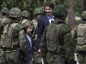 Canadian Prime Minister Justin Trudeau and his son Xavier review an honour guard as they arrive at the International Peacekeeping and Security Centre in Yavoriv, Ukraine Tuesday July 12, 2016.