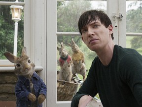 This image released by Columbia Pictures shows Domhnall Gleeson with Peter Rabbit, voiced by James Corden, in a scene from "Peter Rabbit." (Columbia Pictures/Sony via AP)