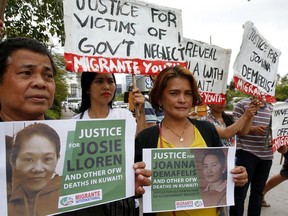 FILE - In this Wednesday, Feb. 21, 2018, file photo, protesters picket the Senate at the start of the probe in the death of an overseas worker in Kuwait, Pasay city south of Manila, Philippines. The senate probe was prompted by the discovery of the corpse of Filipino domestic help Joanna Demafelis stuffed in a freezer in Kuwait with President Rodrigo Duterte ordering repatriations of thousands of Filipino workers and banned future deployments to the oil-rich nation.