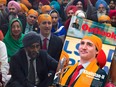 Prime Minister Justin Trudeau sits with members of the Sikh community and government caucus during a Vaisakhi Celebration on Parliament Hill in Ottawa, Monday, April 11, 2016 alongside the cover of the Feb. 12, 2018 issue of Outlook India.