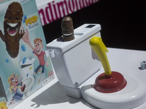 Flushin' Frenzy from Mattel is on display at Toy Fair in New York on Tuesday, Feb. 20, 2018. Reflexes and a toilet plunger combine to make a plastic poop fly. (AP Photo/Mark Lennihan)