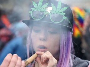 A woman smokes a fattie on Parliament Hill in Ottawa in this April 20, 2017, file photo.  
(LARS HAGBERG/AFP/Getty Images)