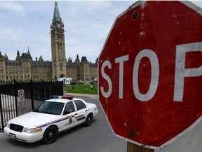 In this file photo, an RCMP cruiser drives past a stop sign on Parliament Hill in Ottawa on June 13, 2013.