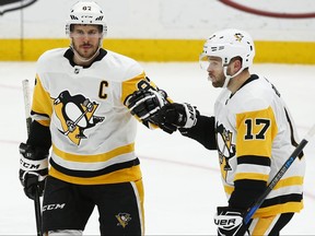 Penguins captain Sidney Crosby, left, is congratulated by Bryan Rust after scoring a goal during the third period against the Blues in St. Louis on Sunday, Feb. 11, 2018.