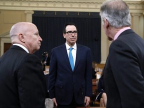 U.S. Treasury Secretary Steven Mnuchin, centre, talks with House Ways and Means Committee Chair Rep. Kevin Brady, R-Texas, left, and Ranking Member Rep. Richard Neal, D-Fla., before testifying on the FY19 budget at a hearing, Thursday, Feb. 15, 2018, on Capitol Hill in Washington.