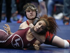 In this Friday, Feb. 16, 2018 photo, Euless Trinity's Mack Beggs, top, wrestles Lewisville's Elyse Nelson in the second round of the 110-pound girls division during the 6A Region II wrestling meet at Allen High School in Allen, Texas. (Jae S. Lee/The Dallas Morning News via AP)