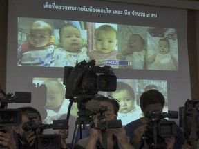 FILE - In this Aug. 12, 2014, file photo, the media attend a press briefing where Thai police display projected pictures of surrogate babies born to a Japanese man who is at the center of a surrogacy scandal during a press conference at the police headquarters in Chonburi, Thailand. Bangkok's Central Juvenile and Family Court on Tuesday gave Mitsutoki Shigeta sole legal custody of the children he fathered using Thai surrogate mothers, ruling that he's financially stable and showed his plans to care for them.