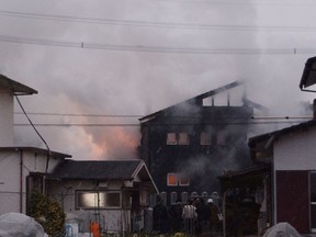 Smoke billows from the site where a Japanese military helicopter carrying two crewmembers crashed in Kanzaki, southwestern Japan on Monday,  Feb. 5, 2018, ripping the top floor off a house and setting it on fire.  The Defense Ministry said both crewmembers suffered heart and lung failure. (Ami Takahashi/Kyodo News via AP)