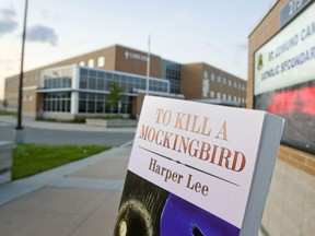 In this file photo, a copy of the Harper Lee classic novel To Kill A Mockingbird is held outside a high school.