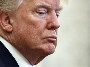 President Donald Trump listens during a meeting with North Korean defectors where he talked with reporters about allowing the release of a secret memo on the FBI's role in the Russia inquiry, in the Oval Office of the White House, Friday, Feb. 2, 2018, in Washington.