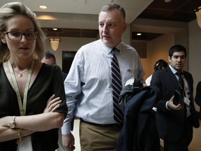 In this Jan. 16, 2018, file photo, Rep. Thomas Rooney, R-Fla., centre, talks with reporters as he leaves a House intelligence committee meeting on Capitol Hill in Washington. (AP Photo/Jacquelyn Martin, File)