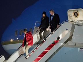 U.S. President Donald Trump, first lady Melania Trump and their son Barron Trump disembark Air Force One upon arrival at Andrews Air Force Base, Md., Monday, Feb. 19, 2018.