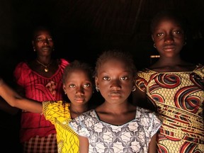 A woman and her daughters stand in their home, in the village of Cambadju in Guinea-Bissau, the first in the country to renounce female genital mutilation/cutting.
