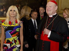Cardinal Gianfranco Ravasi and designer Donatella Versace arrive at Palazzo Colonna in Rome, Monday, Feb. 26, 2018.  The Vatican is loaning some of its most beautiful liturgical vestments, jeweled miter caps and historic papal tiaras for an upcoming exhibit on Catholic influences in fashion at the Metropolitan Museum of Art. The Vatican culture minister, Cardinal Gianfranco Ravasi, joined Vogue Editor-in-Chief Anna Wintour and designer Donatella Versace in Rome on Monday to display a few of the Vatican treasures at the Palazzo Colonna, a onetime papal residence. "Heavenly Bodies: Fashion and the Catholic Imagination" is set to open May 10 at the Met's Costume Institute in New York.