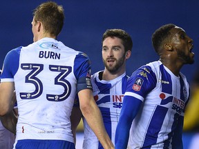 Wigan Athletic striker Will Grigg celebrates with teammates after scoring his team's first goal during the English FA Cup fifth round match against Manchester City at the DW Stadium in Wigan on February 19, 2018. (OLI SCARFF/Getty Images)