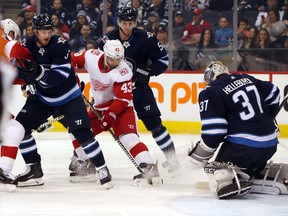 Red Wings’ Darren Helm holds his ground in front of Jets goaltender Connor Hellebuyck the Bell MTS Place Friday night. Brook Jones/Postmedia Network