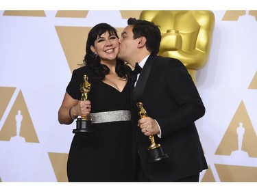 Kristen Anderson-Lopez, left, and Robert Lopez, winners of the award for best original song for "Remember Me" from "Coco", pose in the press room at the Oscars on Sunday, March 4, 2018, at the Dolby Theatre in Los Angeles.