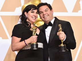 Composers Kristen Anderson-Lopez (L) and Robert Lopez, winners of the Best Original Song award for 'Remember Me' from 'Coco,'  pose in the press room during the 90th Annual Academy Awards at Hollywood & Highland Center on March 4, 2018 in Hollywood, California.