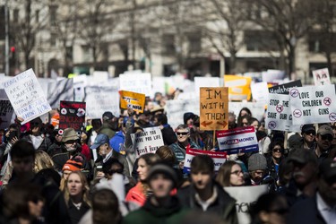 Demonstrators hold signs at the start of the March for Our Lives rally March 24, 2018 in Washington, DC.