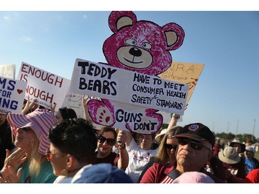 People hold signs as they participate in the March For Our Lives event at Pine Trails Park before walking to Marjory Stoneman Douglas High School on March 24, 2018 in Parkland, Florida. The event was one of many scheduled around the United States calling for gun control after a gunman killed 17 people on February 14 at the high school.