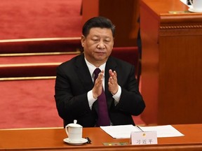 China's President Xi Jinping applauds during the fifth plenary session of the first session of the 13th National People's Congress (NPC) at the Great Hall of the People in Beijing on March 17, 2018.