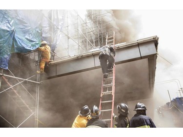 Firemen try to escape from heavy smoke at the Waterfront Manila Pavilion building, after a fire broke out at the hotel and casino complex in Manila on March 18, 2018. (TED ALJIBE/AFP/Getty Images)