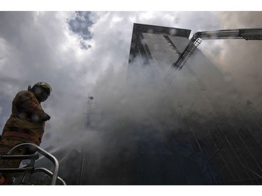 A fireman stands on top of a firetruck next to heavy smoke at the Waterfront Manila Pavilion building, after a fire broke out at the hotel and casino complex in Manila on March 18, 2018. (TED ALJIBE/AFP/Getty Images)