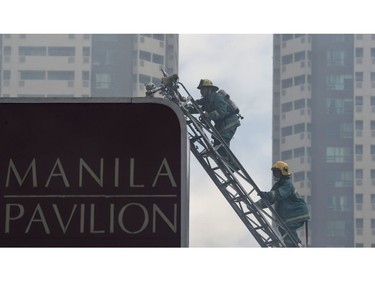 Firemen climb a truck ladder as they battle a fire that hit the Waterfront Manila Pavilion building, a hotel and casino complex in Manila on March 18, 2018. 
(TED ALJIBE/AFP/Getty Images)