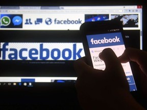 A cellphone and a computer screen display the logo of the social networking site Facebook on March 22, 2018, in Asuncion.