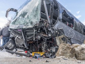 A rescuer works at the wreckage of a bus that crashed in Gosen near Salzburg, Austria, Wednesday, March 28, 2018. (Werner Kerschbaumayr /FotoKerschi.at/Kerschbaummayr via AP)
