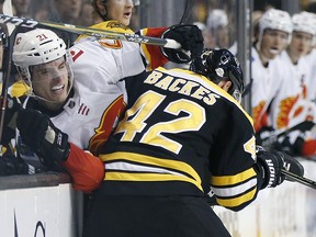 Boston Bruins' David Backes (42) checks Calgary Flames' Garnet Hathaway (21) in Boston, Tuesday, Feb. 13, 2018. (AP Photo/Michael Dwyer)