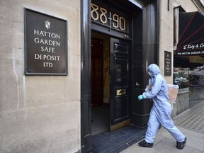 In this file photo dated April 7, 2015, a police forensics officer enters the Hatton Garden Safe Deposit company, in London. (Dominic Lipinski/PA via AP)