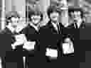  In this Oct. 26, 1965 file photo The Beatles, from left: Ringo Starr, John Lennon, Paul McCartney and George Harrison smile as they display the Member of The Order of The British Empire medals presented to them by Queen Elizabeth II in a ceremony in Buckingham Palace in London, England. 