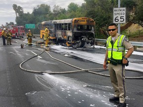 In this image released by the California Highway Patrol West Valley shows CHP Officer Qayum at the scene where a school bus fire caught fire on CA-101 Los Angeles freeway near Woodland Hills area of Los Angeles Wednesday, March 7, 2018. (Officer J. Rodriguez/California Highway Patrol West Valley via AP)