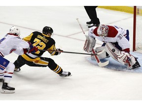 Montreal Canadiens goaltender Antti Niemi (37) stops a shot by Pittsburgh Penguins' Patric Hornqvist (72) with Charles Hudon, left, defending during the first period of an NHL hockey game in Pittsburgh, Saturday, March 31, 2018.