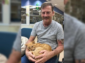 This March 2018 photo made available by the Humane Society of the Treasure Coast in Palm City, Fla., shows Perry Martin with his cat T2.