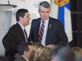Premier Stephen McNeil, right, chats with Geoff MacLellan, government house leader, at a business luncheon in Halifax on Wednesday, Feb. 7, 2018. The Nova Scotia government has introduced legislation that will make it easier for Acadian and black candidates to get elected in certain provincial ridings.