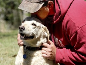 In this Thursday, March 22, 2018 photo, Beaufort resident, Mason Ringer kisses the head of Woody, the dog that rescued him from the Okatie River, in Okatie, S.C.