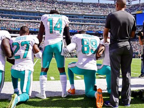 Maurice Smith and Julius Thomas kneel with Jarvis Landry of the Miami Dolphins during the national anthem prior to a game against the New York Jets at MetLife Stadium on September 24, 2017 in East Rutherford, New Jersey. (Steven Ryan/Getty Images)