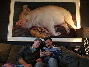 Esther the Wonder Pig is an internet sensation , children's learning book and part of Steve Jenkins (L) and Derek Walter (R) in the family room with an oil painting sent to them by a fan. on Thursday March 15, 2018.