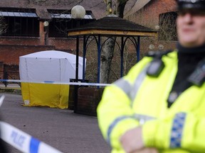 Police officer secures the area as a police tent covers the the spot in Salisbury, England, Tuesday, March 6, 2018, where former Russian spy double agent Sergei Skripal and his companion were found critically ill Sunday following exposure to an "unknown substance".  66-year old Skripal, and unidentified woman companion are being treated in hospital, after they were found unconscious on the park bench.