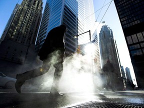 A man makes his way through the city's financial district in downtown Toronto on January 28, 2014. The federal government committed hundreds of millions of dollars in its recent budget to help reinforce Canada's cyber defences -- but if the effort fails to prevent a major attack, Ottawa can always turn to its little-known $102-billion emergency stash. The rainy day fund of highly liquid assets is available to keep the government running for at least a month should the country ever find itself confronted by a severe crisis, such as a cyberattack that impairs access to financial markets.