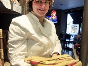 FILE - In this May 16, 2013 photo, Estelle Levy shows sandwiches in her bakery in Paris. Figures released this week have revealed that sales of the jambon-beurre -- the ham and cheese sandwich, a classic of French snacking -- have been surpassed by sales of American-style burgers