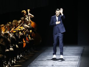 FILE - In this Saturday, Jan. 24, 2015 file photo, Belgian fashion designer Kris van Assche waves after the presentation of Dior's men's fall-winter 2015/2016 collection presented in Paris, France. Christian Dior has announced on Monday, March 19, 2018 that its long-time menswear designer Kris Van Assche is to leave the Parisian fashion house.