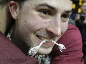 Loyola-Chicago guard Ben Richardson leaves with a piece of the net in his teeth after leading his team to a 78-62 victory over Kansas State in a regional final of the NCAA men's college basketball tournament Saturday, March 24, 2018, in Atlanta. (Curtis Compton/Atlanta Journal-Constitution via AP)