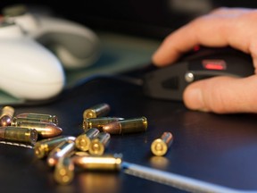 In this stock photo, 9mm bullets sit on a computer desk.