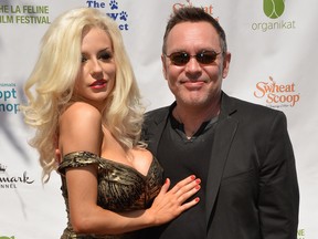 Courtney Stodden and actor Doug Hutchison arrive on the red carpet during the Los Angeles Feline Film Festival at the Memorial Coliseum in Los Angeles on September 21, 2014. The annual event featuring celebrity cats and feline films raises money for local cat sanctuaries and rescue organizations. AFP PHOTO/Mark RALSTON (Photo credit should read MARK RALSTON/AFP/Getty Images)